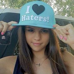 a girl wearing a hat that says i love haters