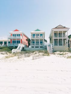 beach houses on the sand with stairs leading up to them