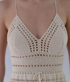 a woman wearing a white crochet dress with spaghetti straps and an open back