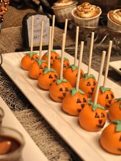 there are many pumpkins on the plate with toothpicks stuck in them to look like jack - o'- lanterns