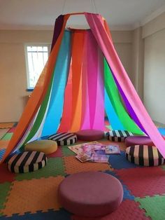 an indoor play area with multicolored tents and pillows