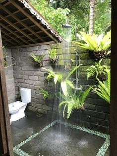 a shower head in the middle of a garden with plants growing on it's sides