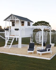 a white swing set sitting on top of a wooden platform