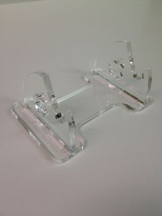 a pair of clear glasses sitting on top of a white table next to each other