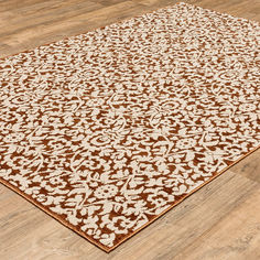 a brown and white area rug on the floor in a room with hardwood floors,