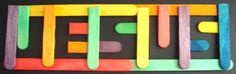 popsicle magnets are arranged in the shape of letters spelling out ice cream on a black surface