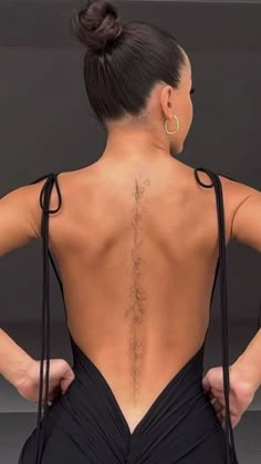 the back of a woman's body with tattoos on her upper and lower back