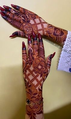 a woman's hand with henna tattoos on it