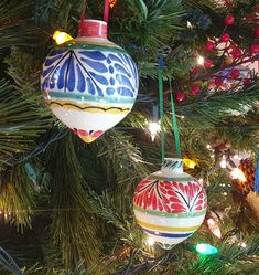 two ornaments are hanging from a christmas tree