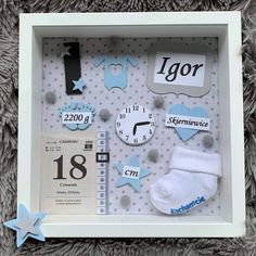 a baby's first birthday shadow box with blue and white items in the frame