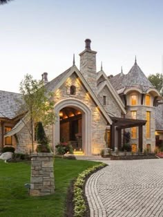 a large brick driveway leading to a stone house