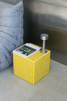 a yellow box sitting on top of a table next to a pillow