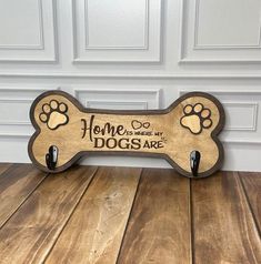 a wooden dog bone sign with paw prints on it's front and back paws