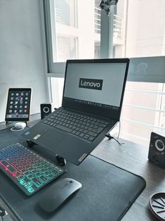 an open laptop computer sitting on top of a desk next to a mouse and keyboard