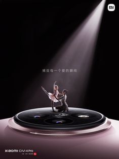 an advertisement featuring two dancers on top of a large disc with light coming from behind it