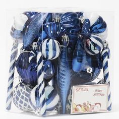 blue and white christmas ornaments in a clear box with tags on the bottom, including candy canes