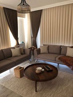 a living room with two couches and a coffee table in front of the window