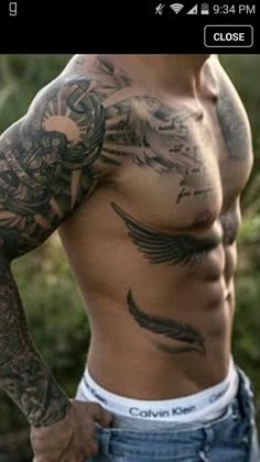 a man with lots of tattoos on his chest and arms is looking at the camera