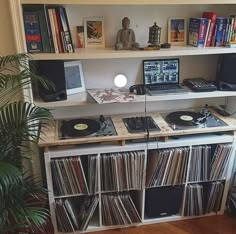 a record player is sitting on top of a shelf in front of a laptop computer