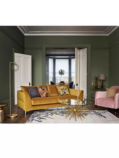 a living room with green walls and yellow couches in front of a large window