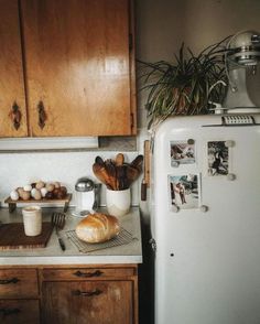 an old fashioned refrigerator in a kitchen with bread and eggs on the counter next to it