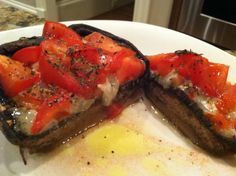 two eggplant halves with tomatoes on them are sitting on a plate next to an egg