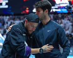 two men embracing each other in front of a crowd