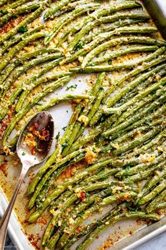 cooked asparagus with parmesan cheese and seasoning in a baking dish