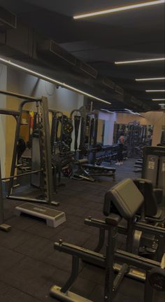 an empty gym with many machines and weights