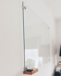 a white wall with a glass shelf on it