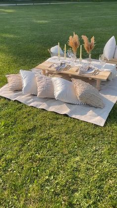 a picnic table set up with pillows and place settings