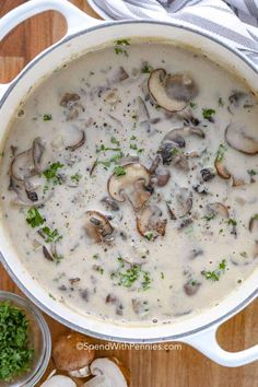 a pot filled with mushroom soup on top of a wooden table