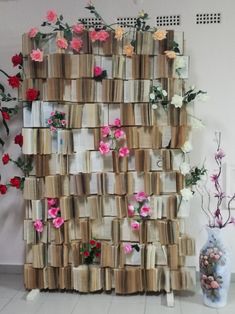 a wall made out of books with flowers on it