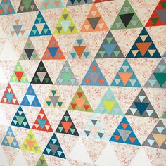 a wall with many different colored triangles on it