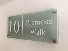 a glass sign that says primrose walk on the side of a white wall