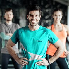 two men and one woman are standing with their hands on their hipss, smiling at the camera