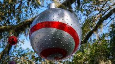 a red and white christmas ornament hanging from a tree