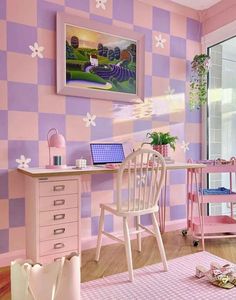 a pink and purple room with checkered wallpaper on the walls, two desks in front of a computer