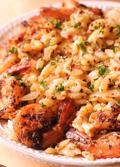 a white plate topped with pasta and shrimp