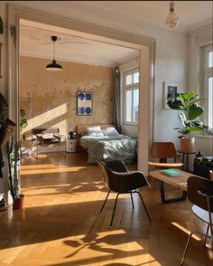 a bedroom with wooden floors and lots of windows