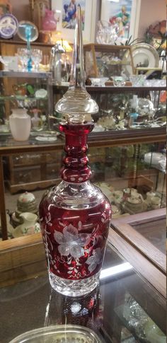 a red glass bottle sitting on top of a table