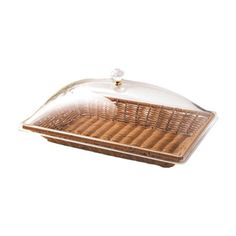 a glass covered casserole dish sitting on top of a white surface with brown wicker