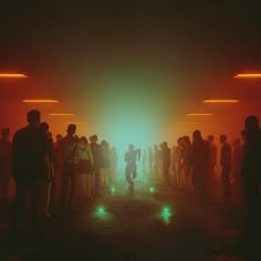 a group of people standing in a dark room with bright lights on the walls and floor