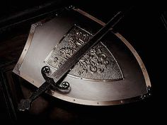 a large metal shield with two swords sticking out of it