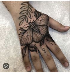 a person's hand with a flower tattoo on it