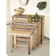 three pieces of wood stacked on top of each other in front of a wall with a clock