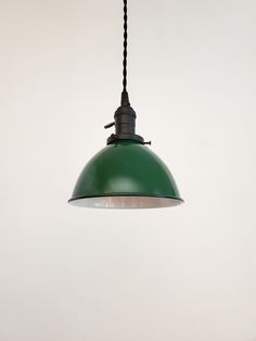 a green light hanging from a ceiling in a room with white walls and flooring