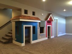 an empty room with two dog houses and stairs