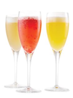 three wine glasses filled with different colored liquids on a white background, side by side