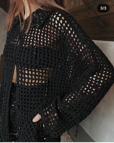 the back of a woman's black crochet top with cutouts on it